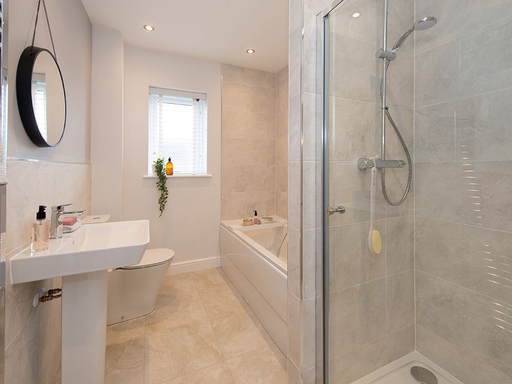 Extensively tiled family bathroom with separate shower
