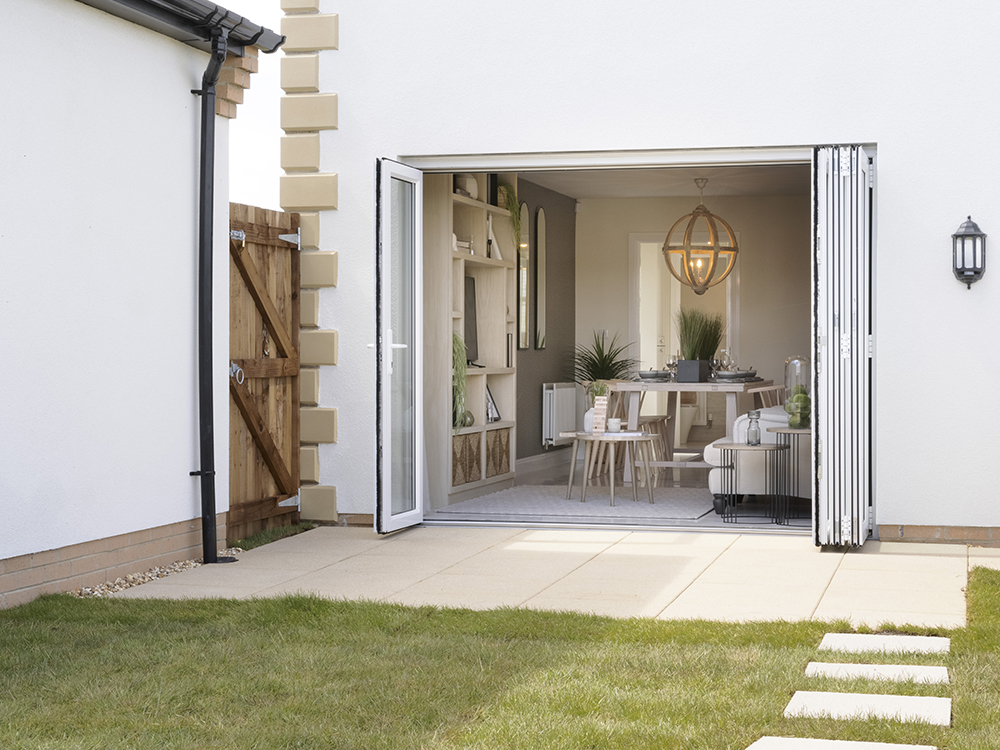 Bi-fold doors to a paved patio and turfed rear garden
