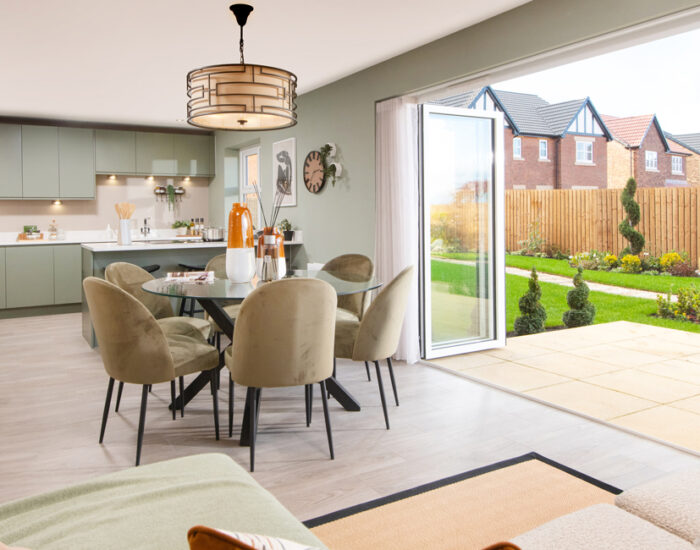 Bi-fold doors opening onto a paved patio and large turfed garden