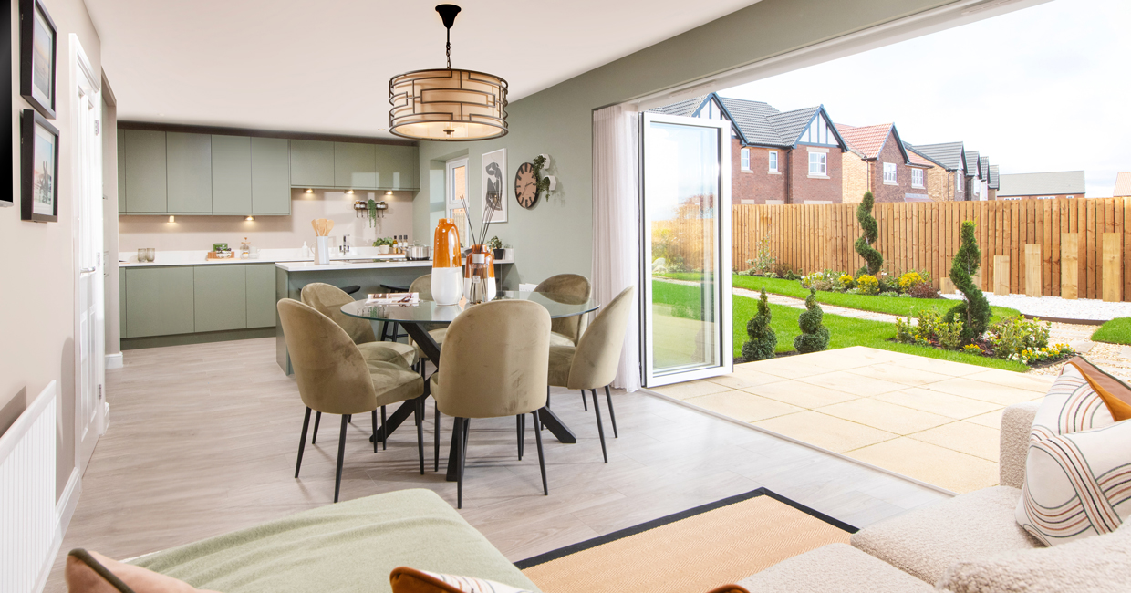 Bi-fold doors opening onto a paved patio and large turfed garden