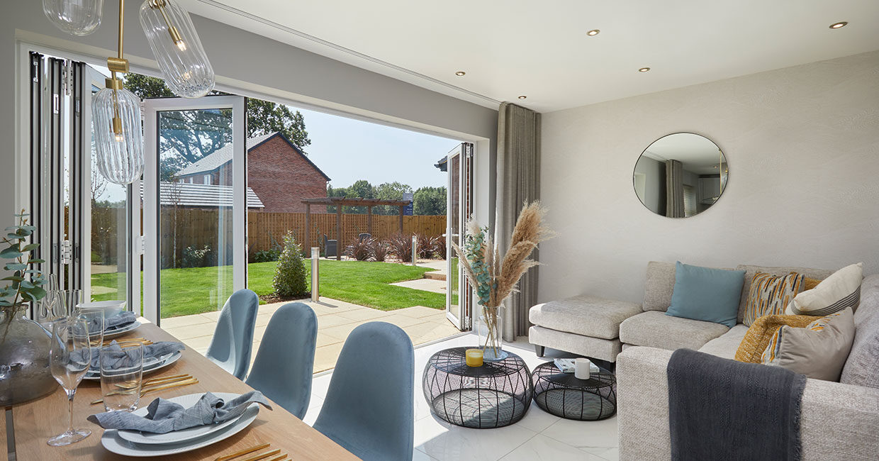 Bi-fold doors opening onto a paved patio and large turfed garden