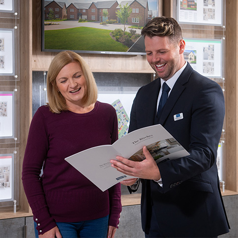 Sales Executive showing customer The Birches brochure