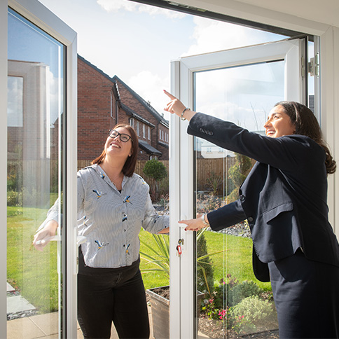 Sales Executive and customer in a Story home looking at the bi-fold doors