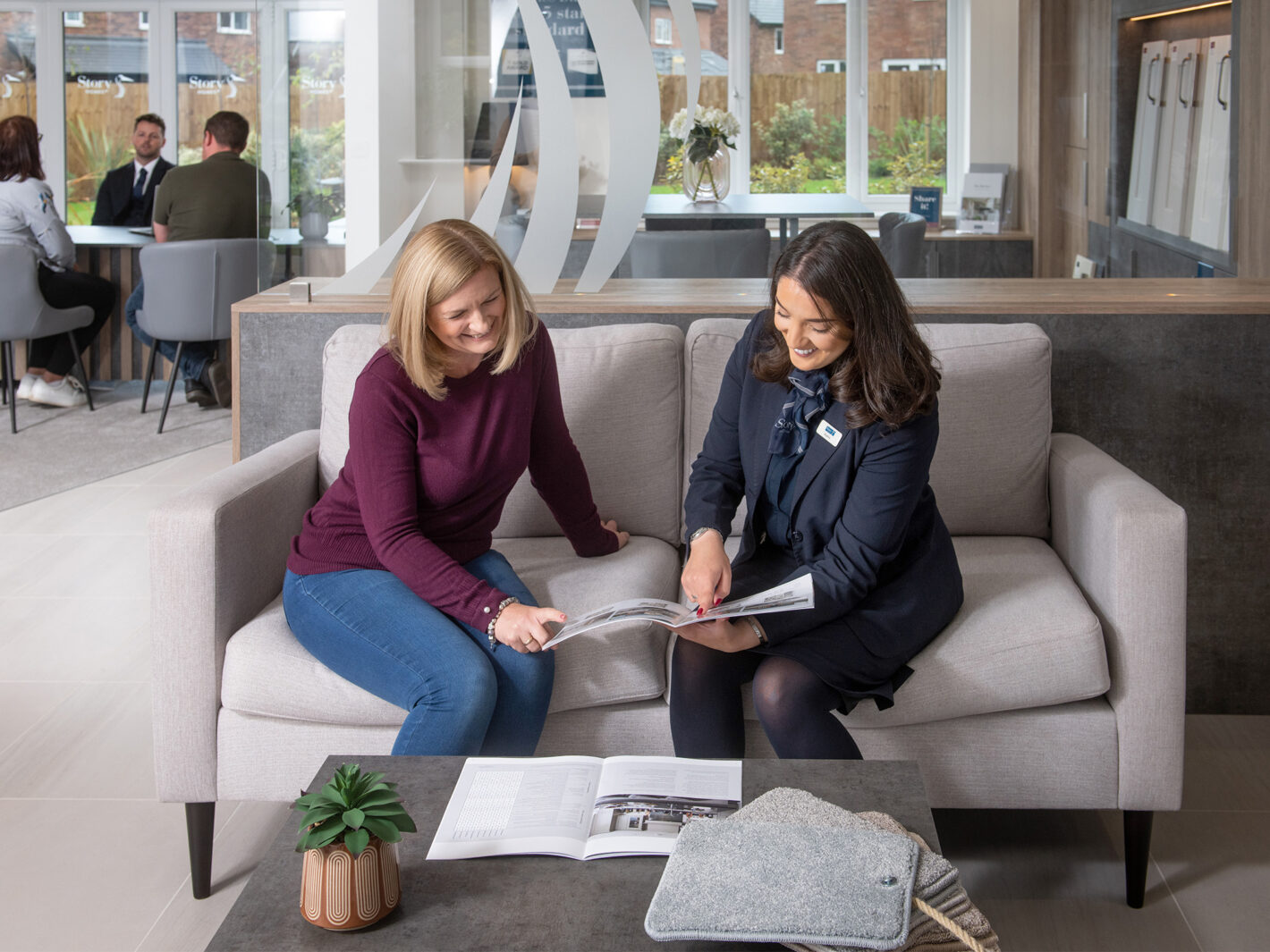 Sales Executive Speaking To Customer In The Marketing Suite At Tithe Gardens