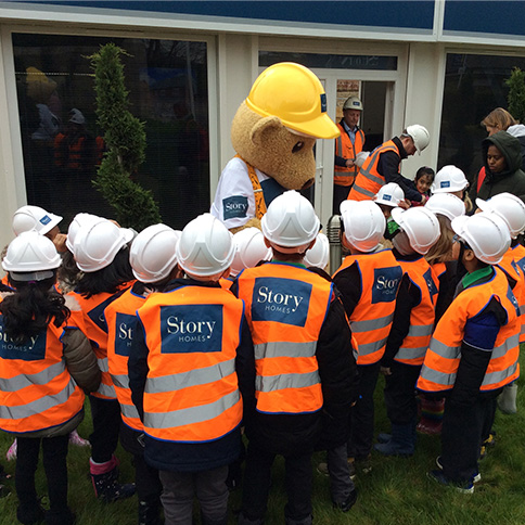 Image of Story Homes Builder Bear with Riverside Academy students on Highfields visit | Story Homes