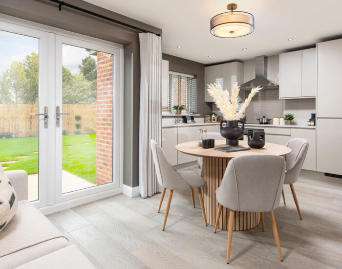 French doors opening onto a paved patio and large turfed garden