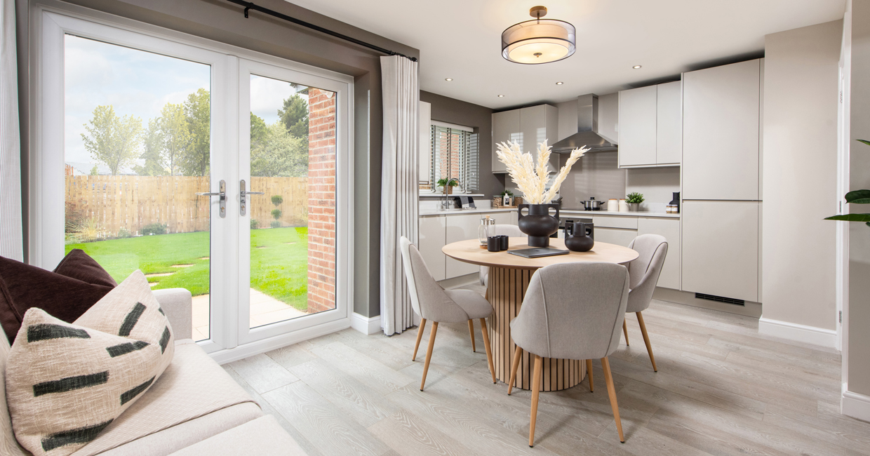 French doors opening onto a paved patio and large turfed garden