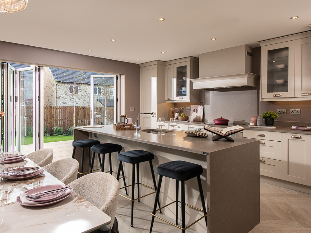 A view of a kitchen and dining area from a Milford show home at Ashwood Grange, by Story Homes.