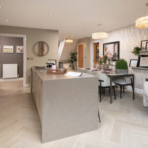 A view of a kitchen and dining area from a Milford show home at Ashwood Grange, by Story Homes.