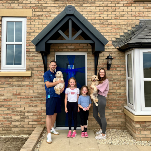 Photo of a family standing outside of their Wilson home at Robinson Fields