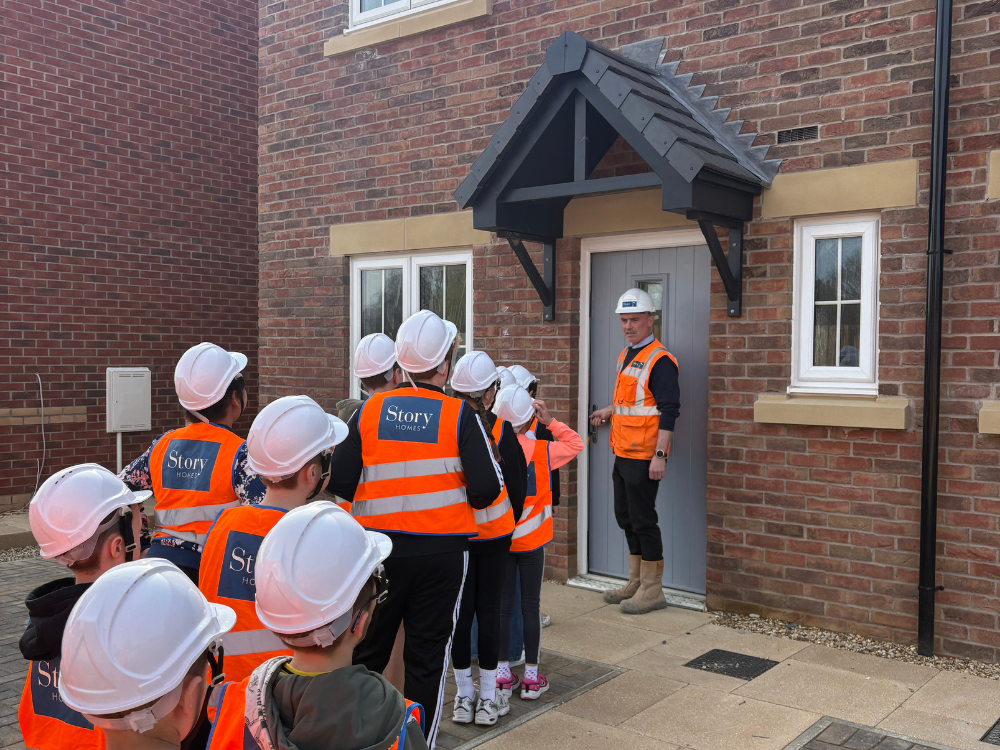 Story Homes Site Project Manager outside of a house with school children
